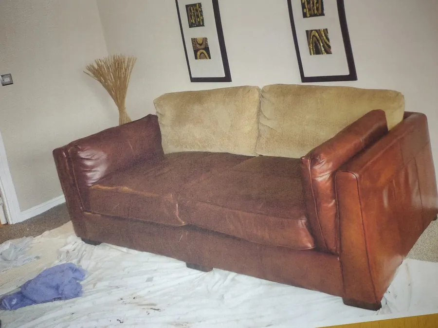 The same sofa after restoration, with rich brown leather and fabric back cushions